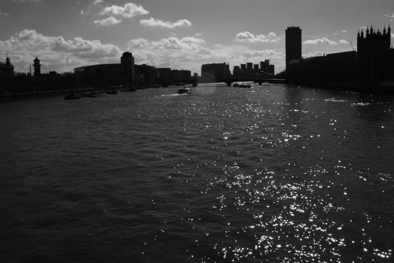 a long body of water with large buildings behind it