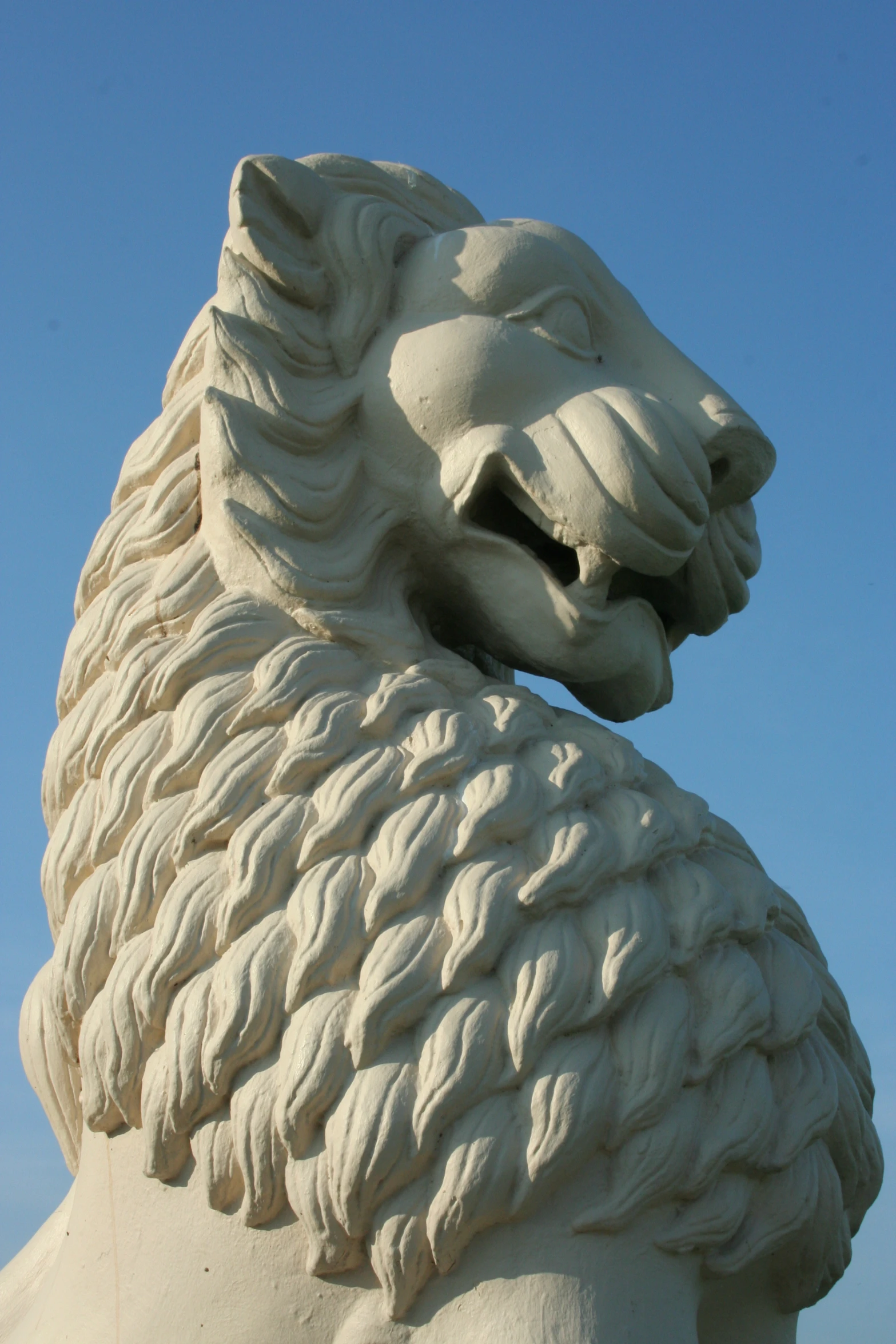 a white lion statue with its mouth open