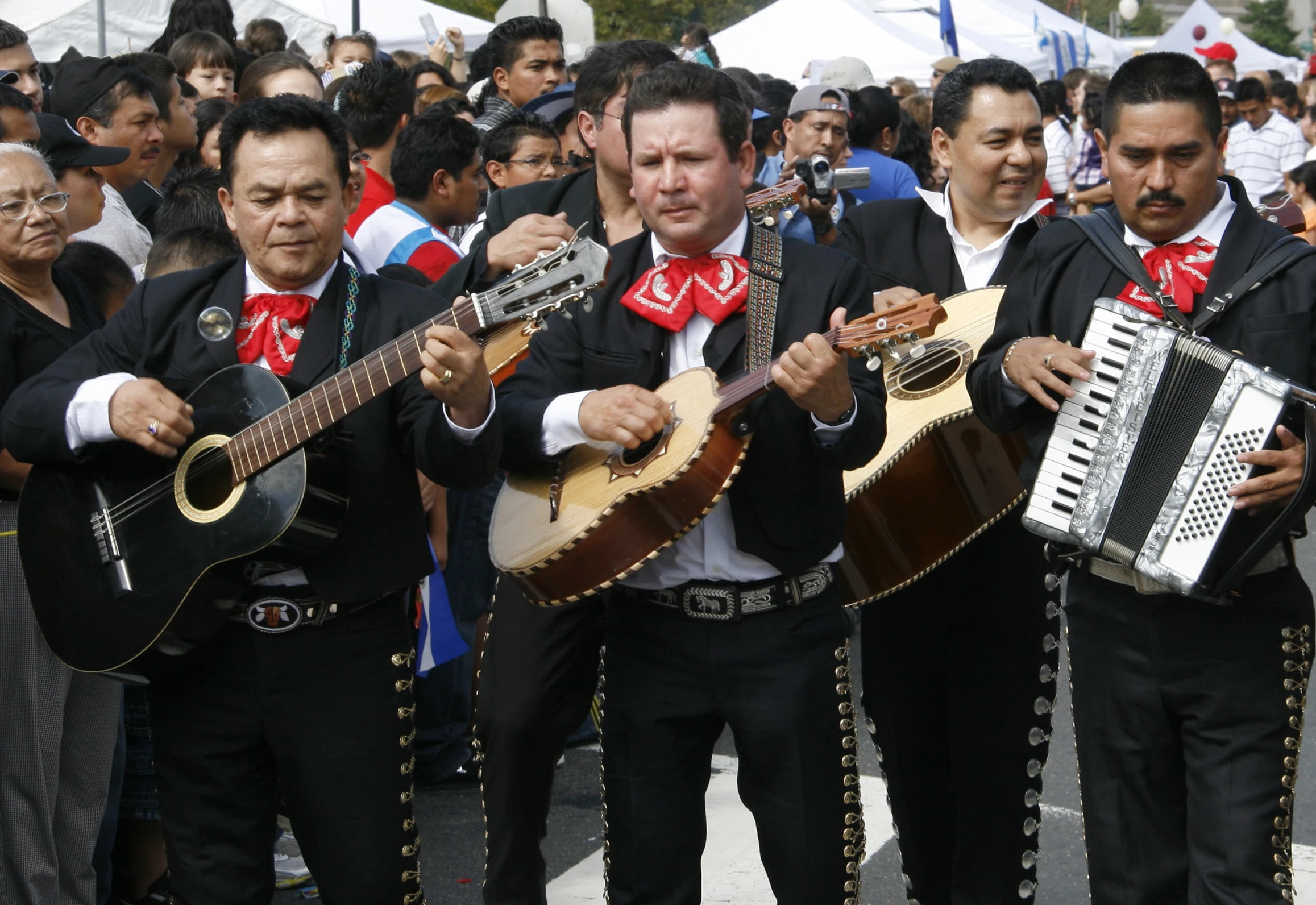 some men are holding their guitars and playing them