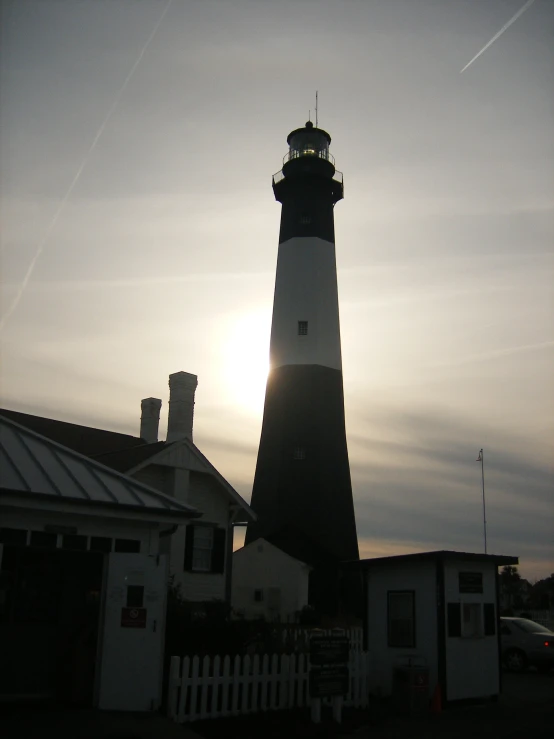 a tall black lighthouse sitting next to a building
