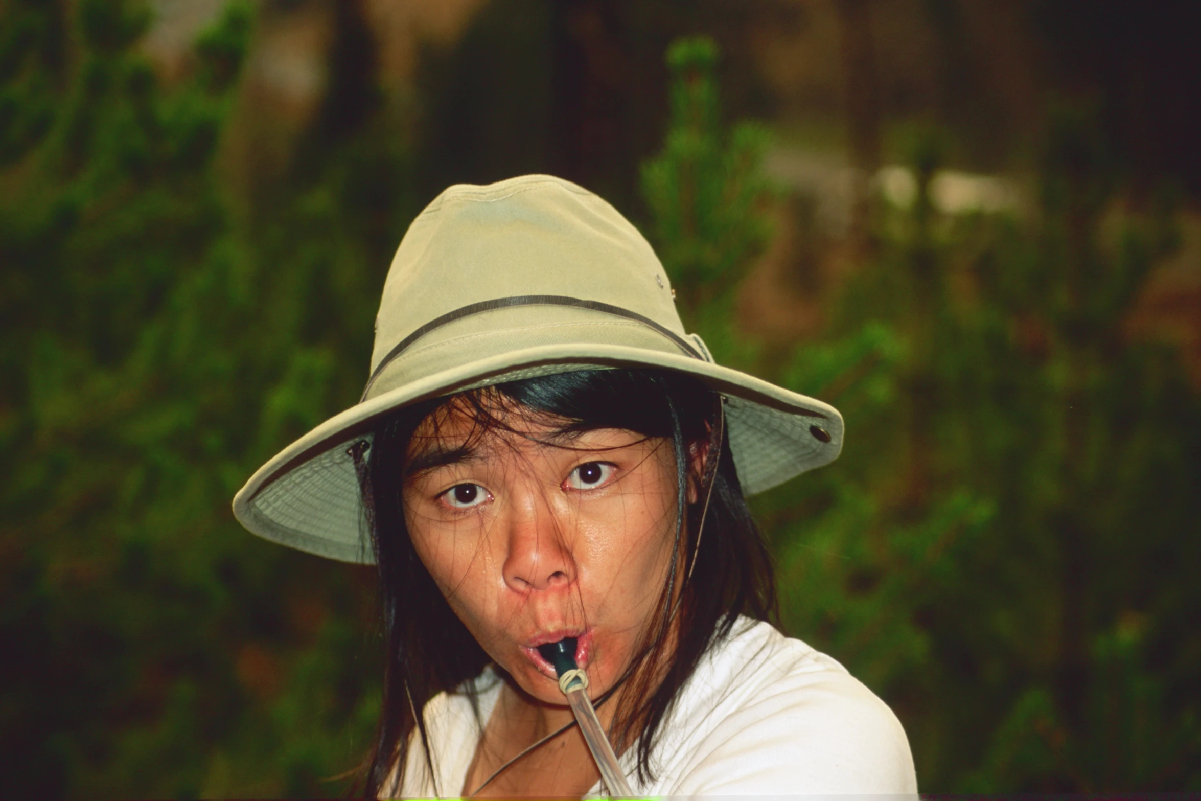 a woman sticking her tongue out with a green hat on