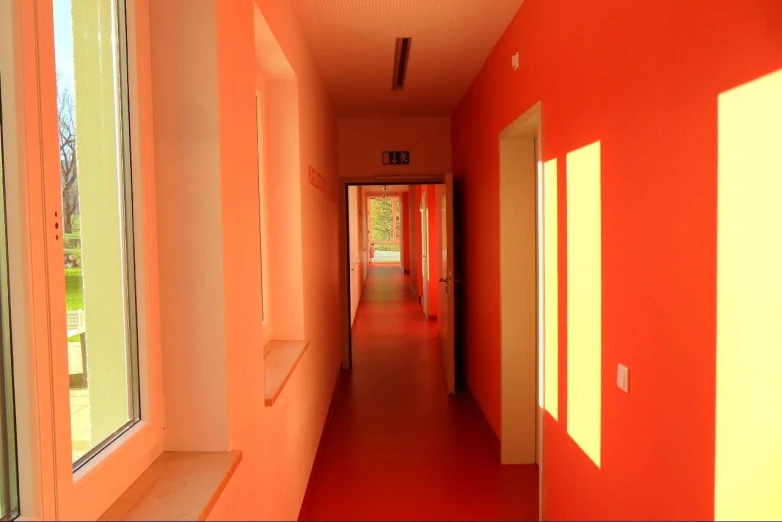 a long hallway is brightly lit by sunlight coming in through a window