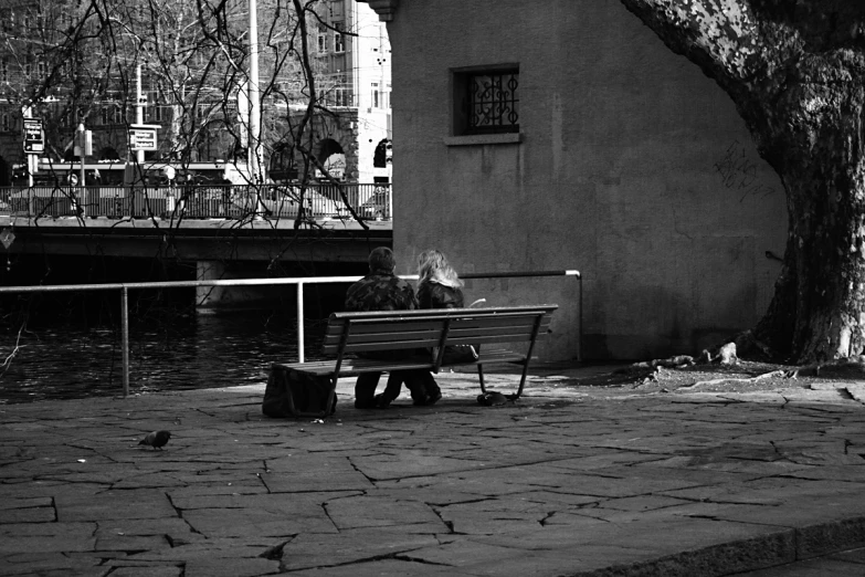 a black and white po of two people seated on benches