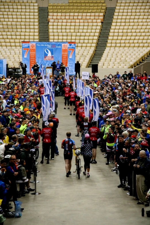 several people walking in the stadium holding flags