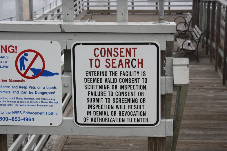 there are two signs next to a pier