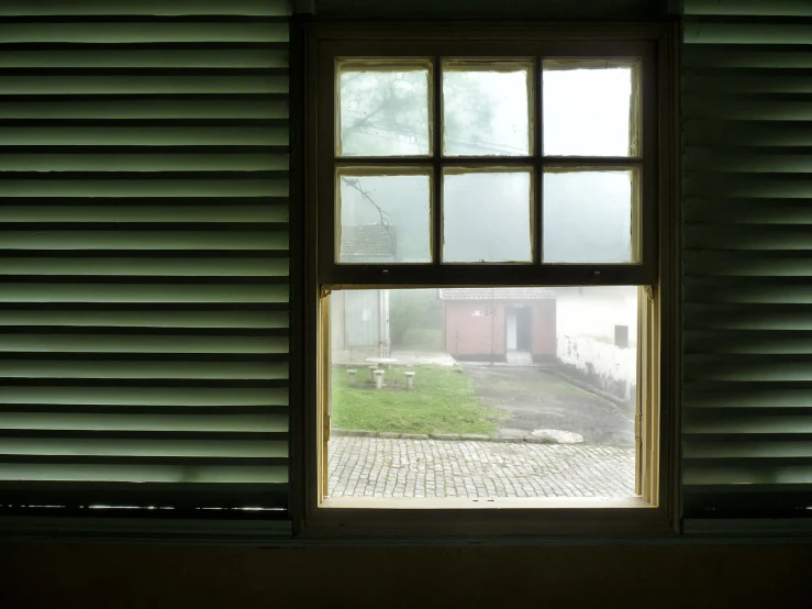 a window sitting in the corner of a wall with blinds