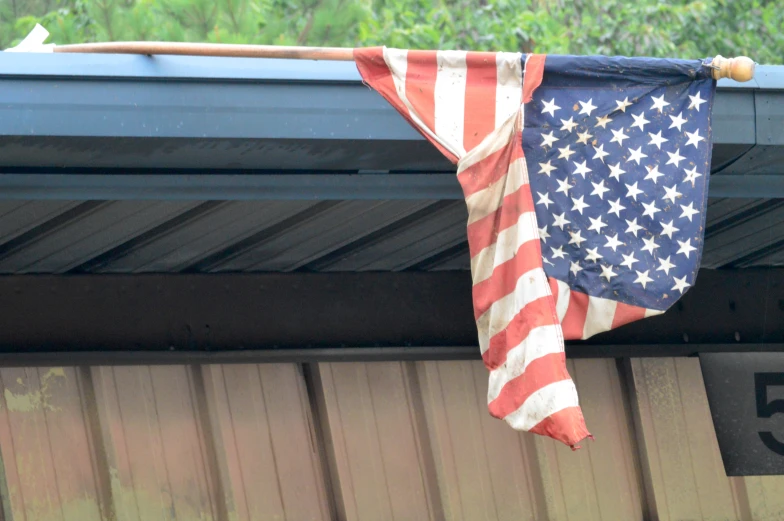 an american flag is hanging on the side of a building