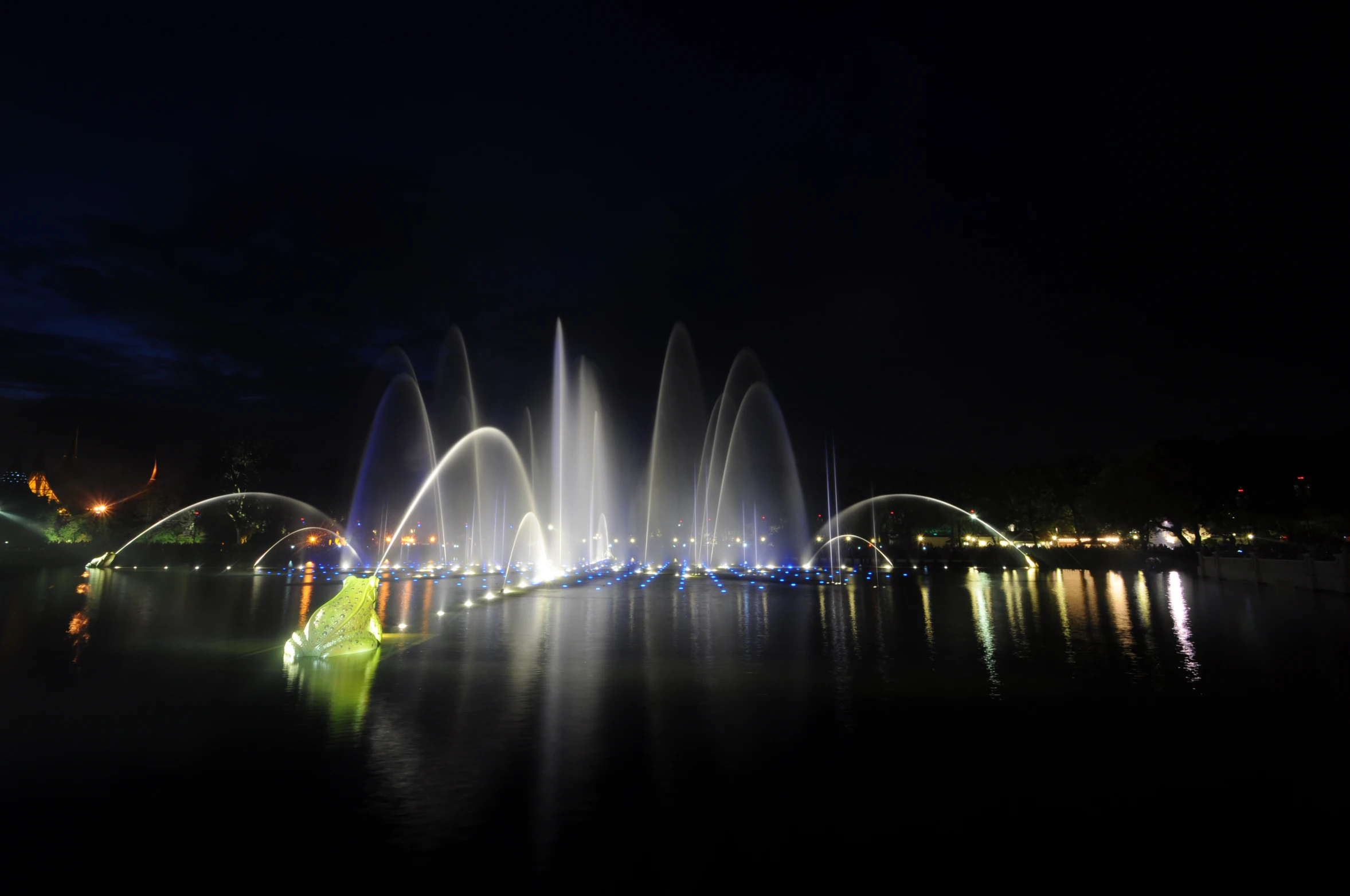 a large fountain with lots of lights on the water