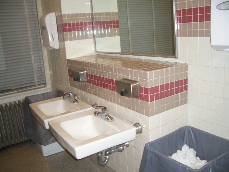 this is a white and brown tiled bathroom with mirrors and sinks