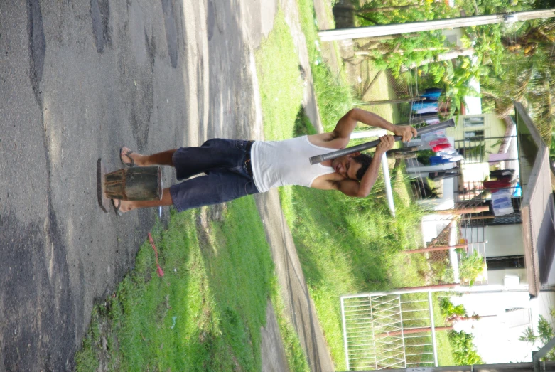 a young man is carrying his skateboard up a hill