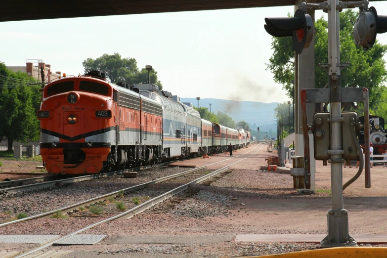 a long passenger train is rolling along the rails