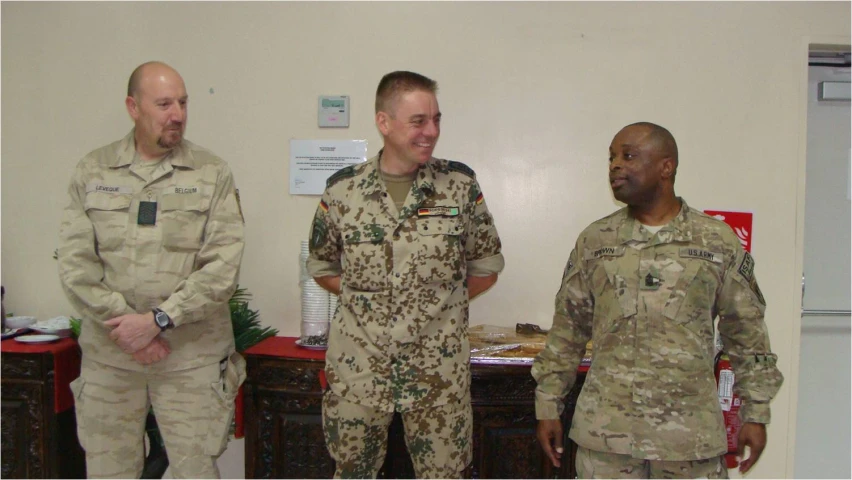 three men dressed in army uniforms are smiling