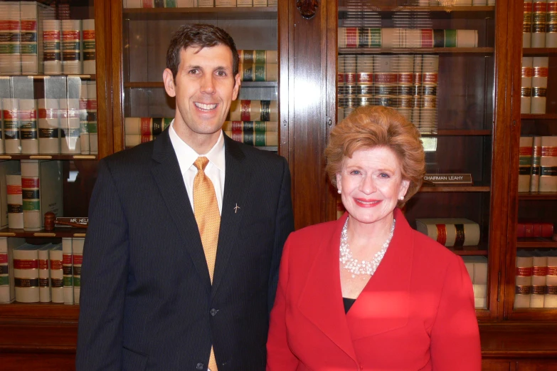 a man and a woman standing in front of a liry full of books