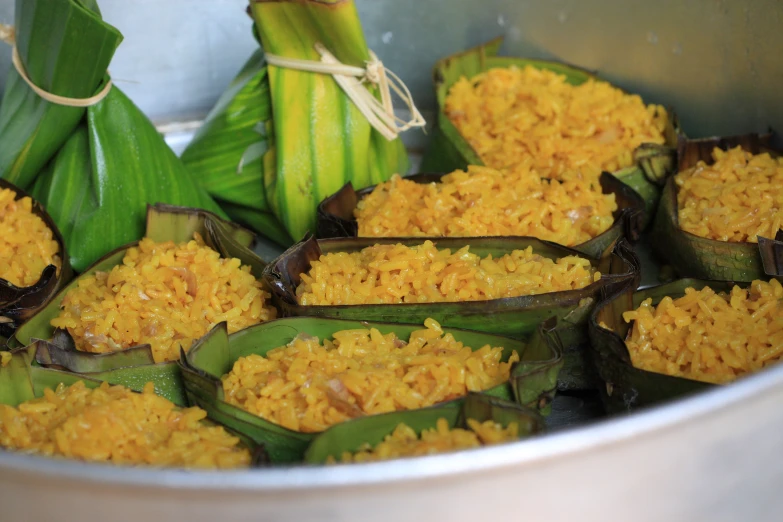 there is rice in a metal bowl with other foods in it