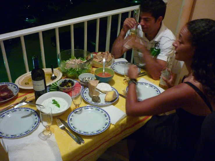 man and woman eating meal in an open balcony