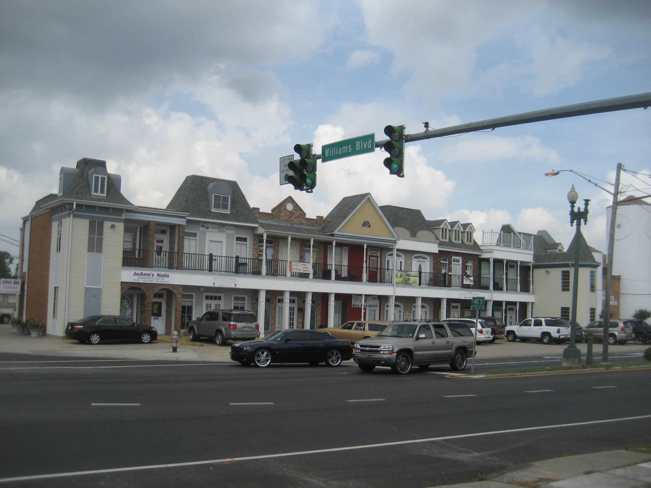 a street light with several different buildings and cars on the road