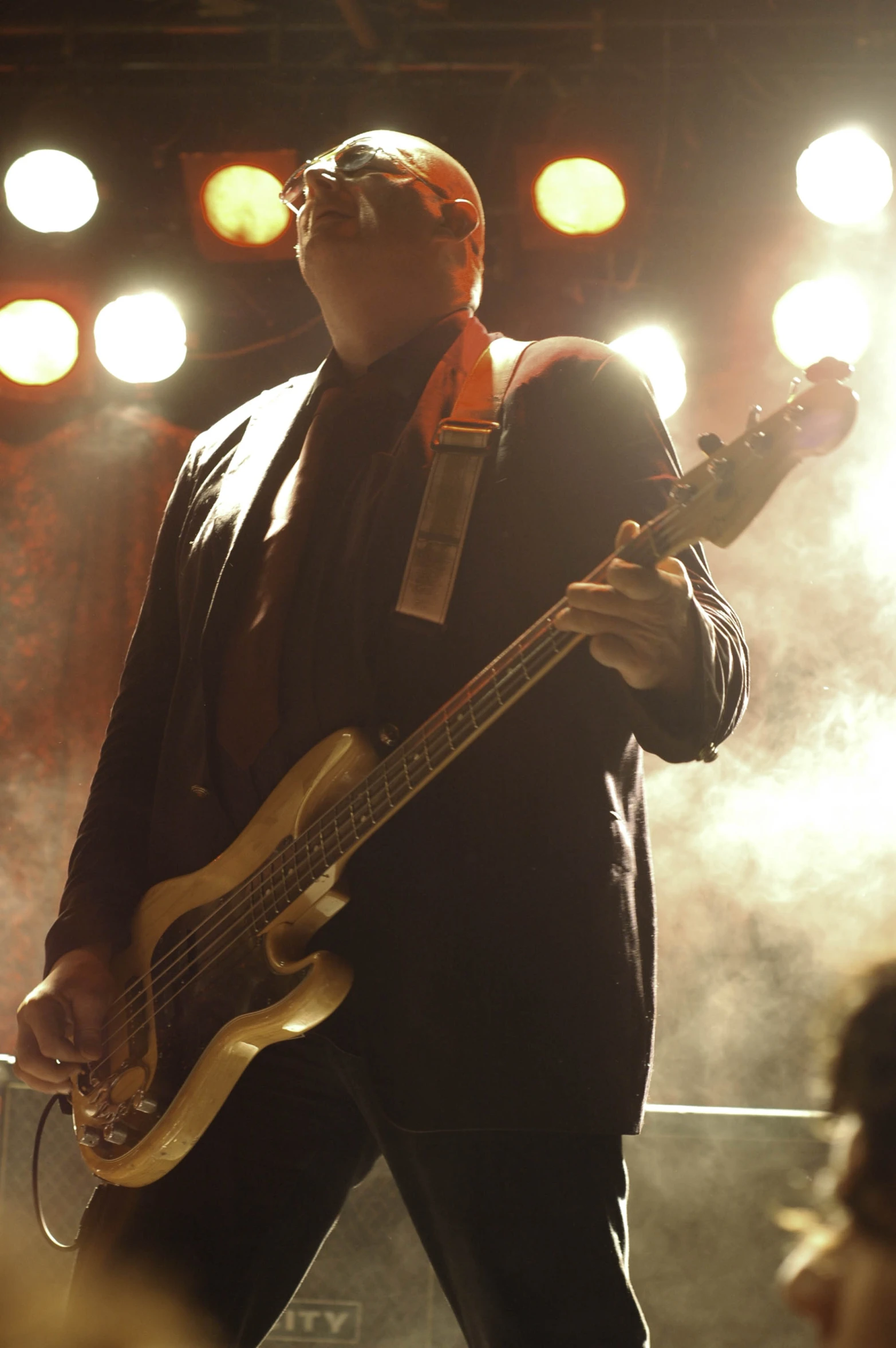 a man with a guitar standing in front of an audience