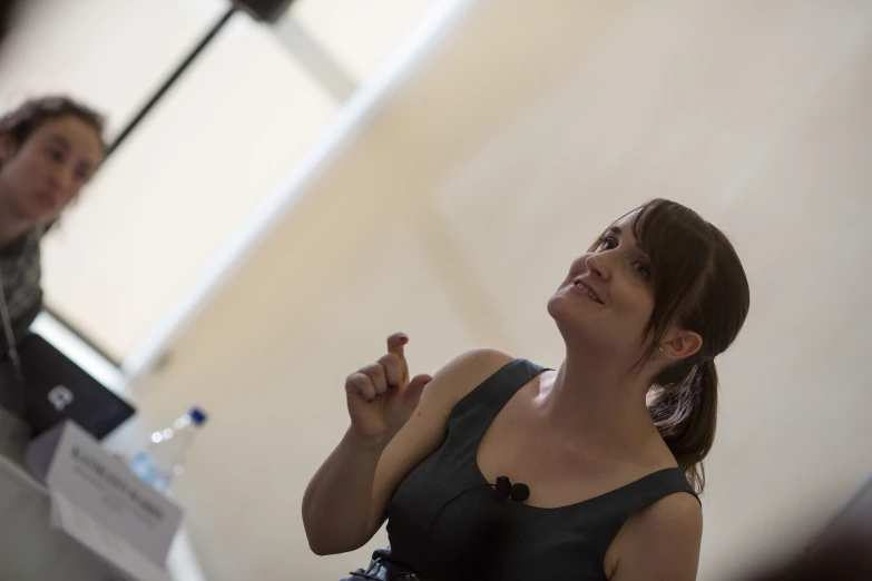 a woman sitting at a desk talking to someone