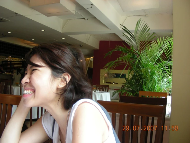 woman sitting on bench and smiling at a restaurant