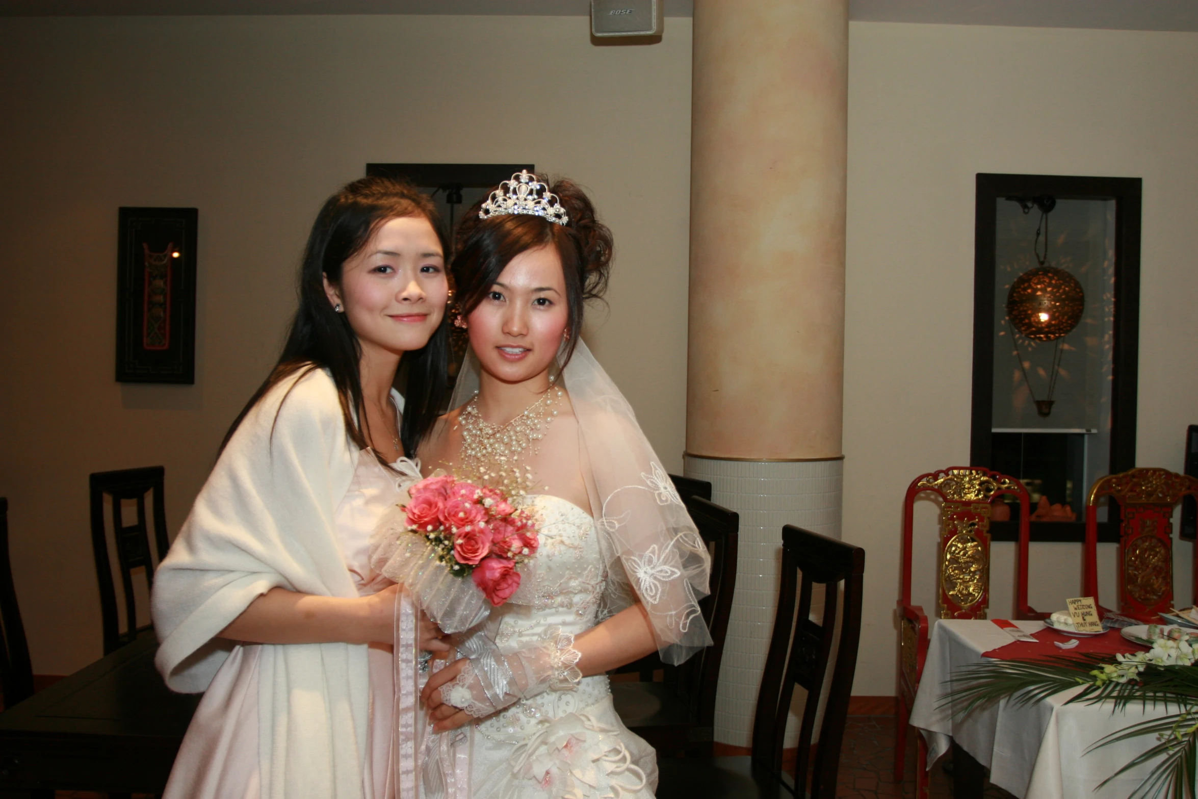 two women in wedding clothes at a table