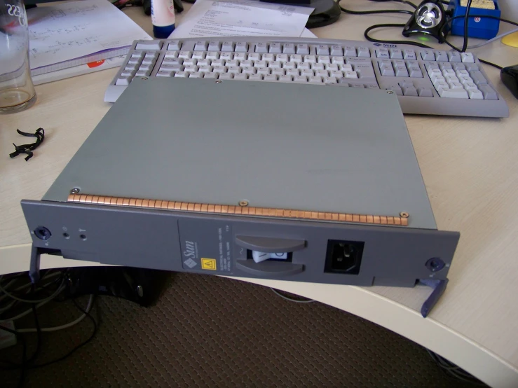 a grey computer with a ruler on top of it