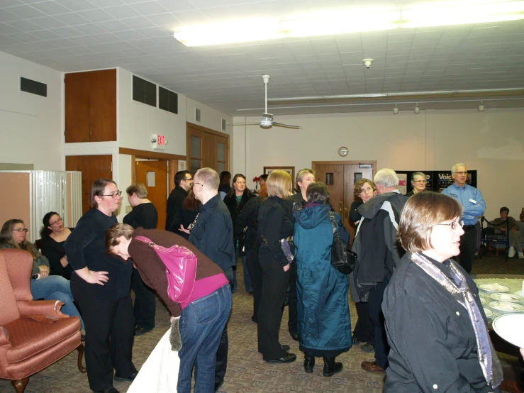 a group of people standing in a building next to each other