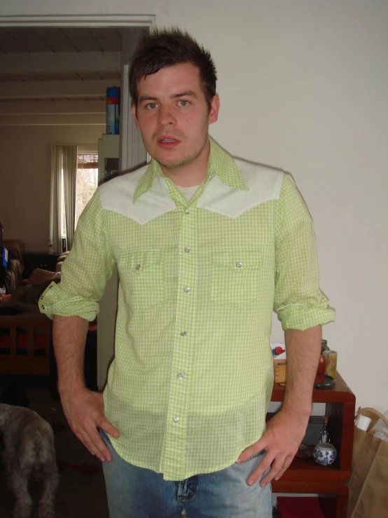 a man wearing a green shirt with his hands on his hips