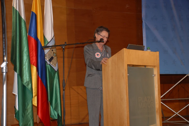 an older man in business attire speaking into a microphone