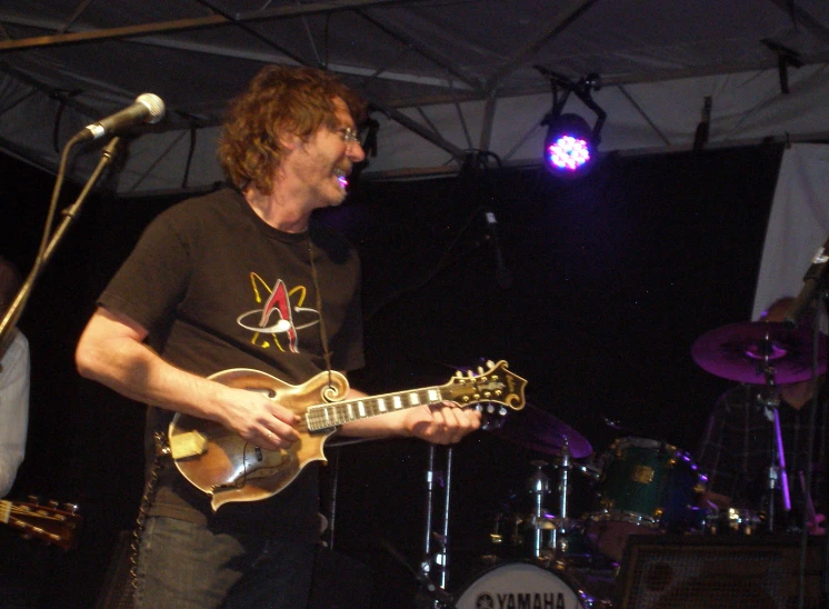 a musician plays his guitar on stage at a festival