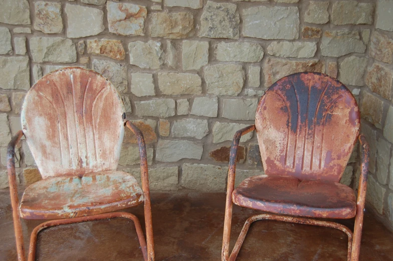 two dirty old chair sit next to each other