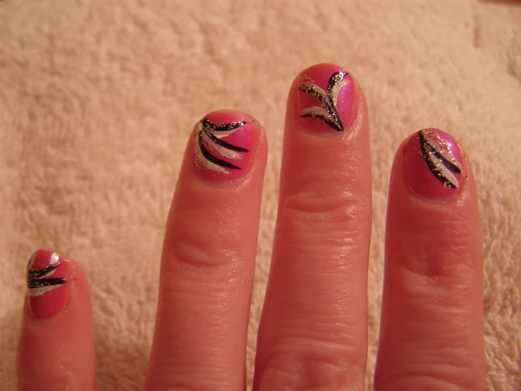 a person holding a pink and black manicure with two different designs