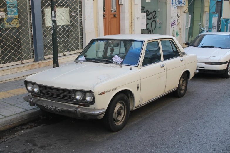 two cars parked on the side of the road next to a building