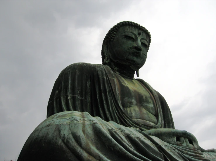 there is a statue of a buddha with head tilted back