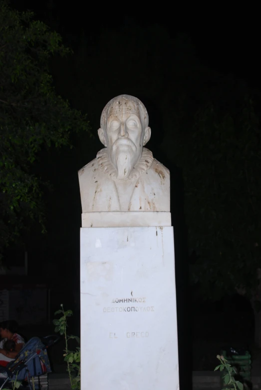 a bust of a man sitting in front of a tree