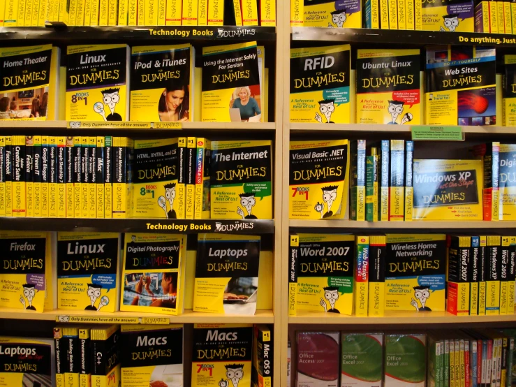 many yellow books are on shelves with a cat on one