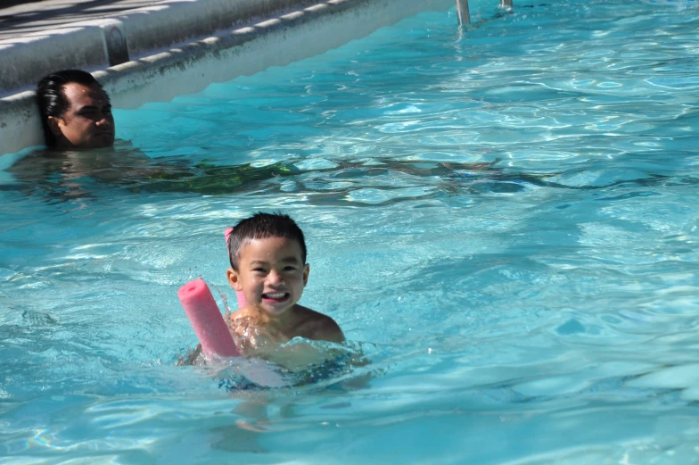 a  is holding a paddle while swimming in the pool