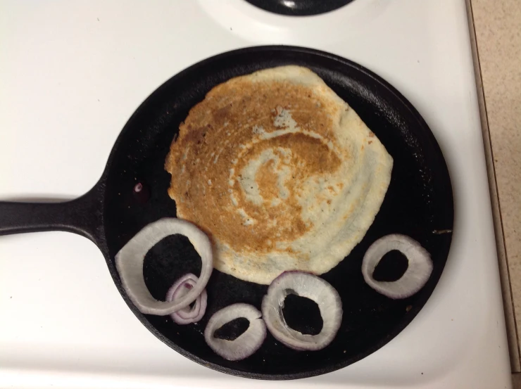 there is a pancake on the stove with onions