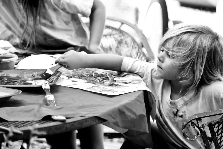 two children sitting at an outside restaurant table