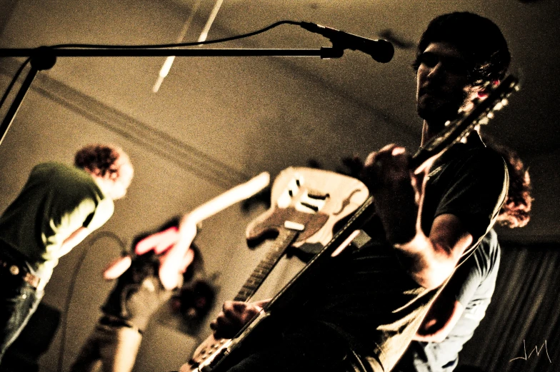 a man holding a guitar while standing on stage