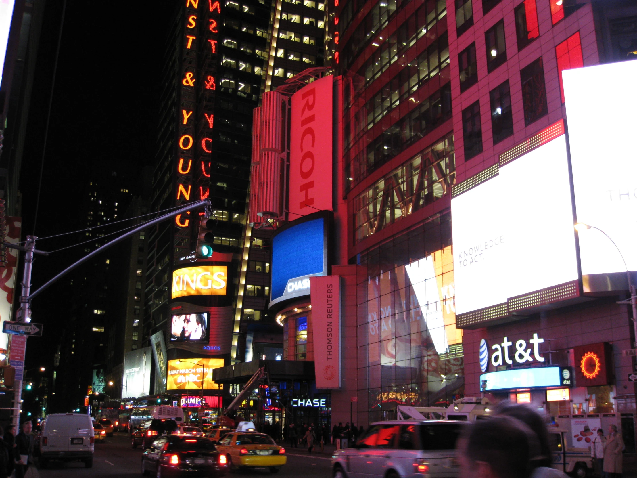 vehicles are driving through an intersection in a big city