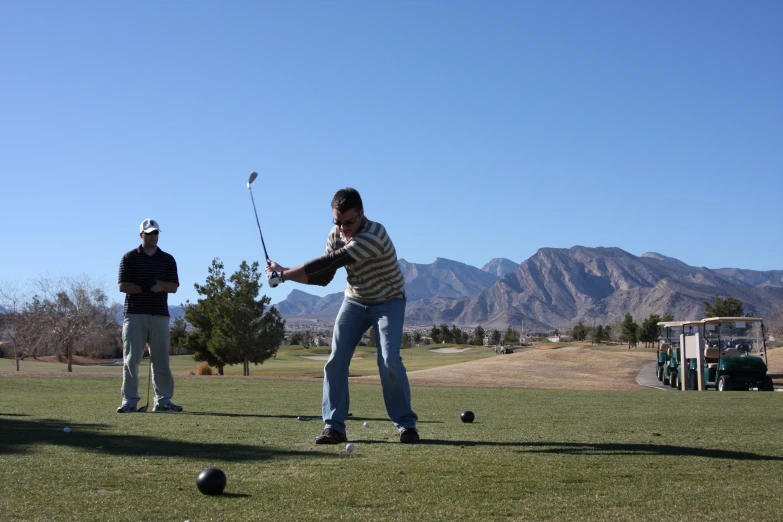 two men playing a game of golf on a golf course