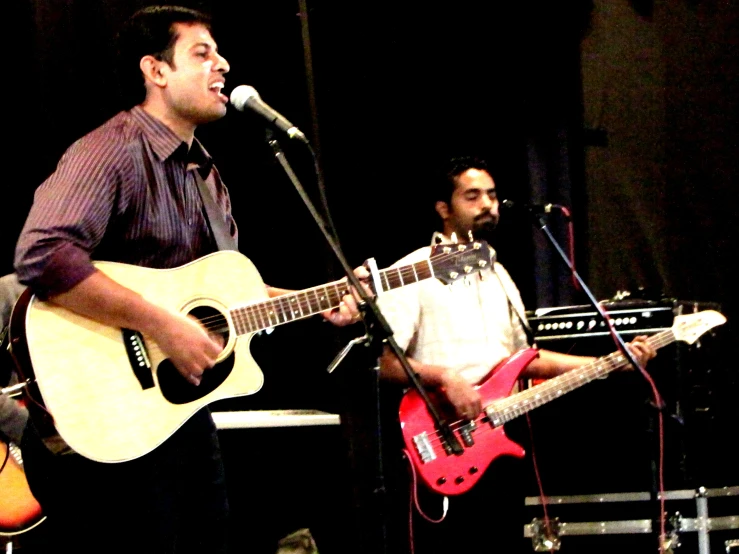 there are some men on stage with guitars