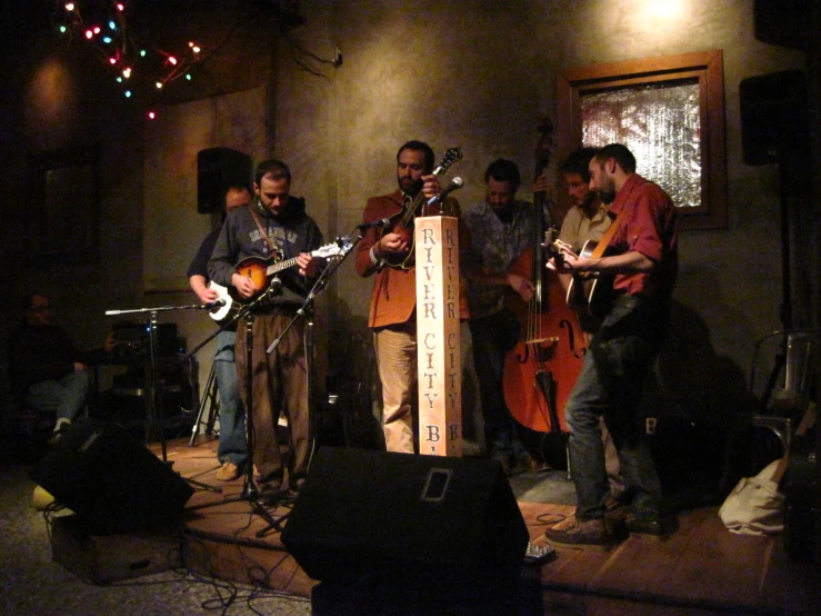 three men are playing guitars in a room