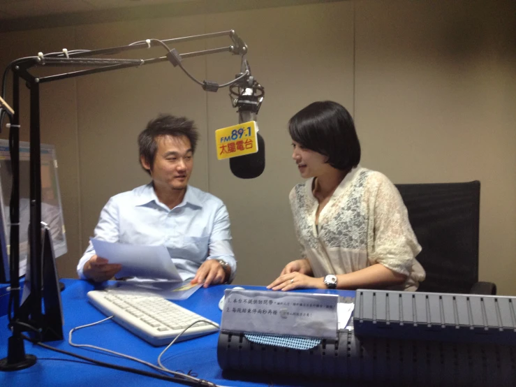 a woman sitting next to a man at a desk