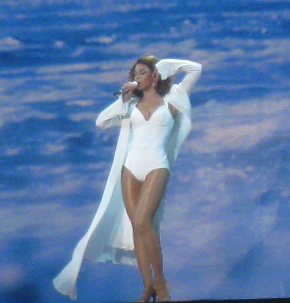 the lady is dressed up and performing in a white costume