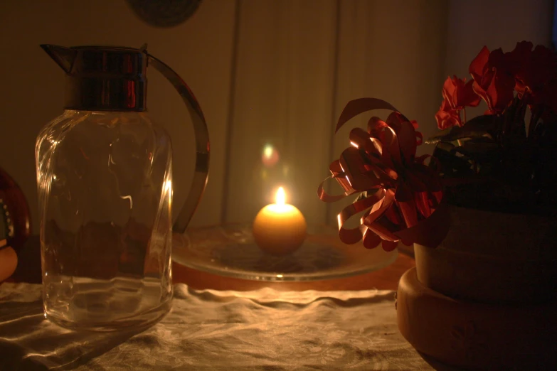 a candle is shown near a vase and flower pot