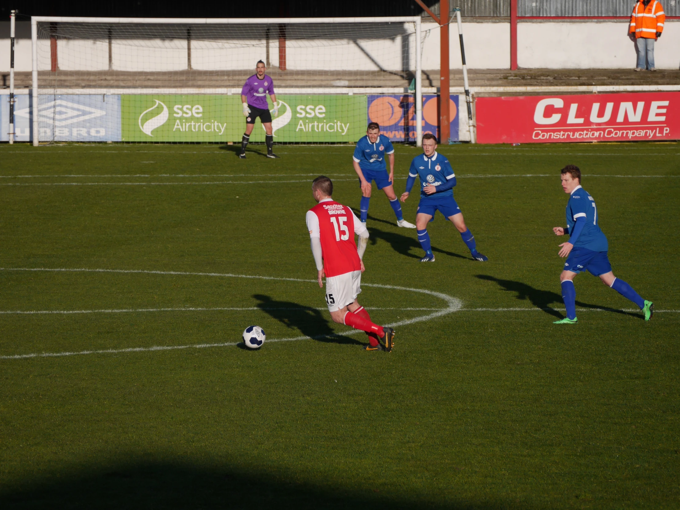 two teams of men playing soccer on a grass field