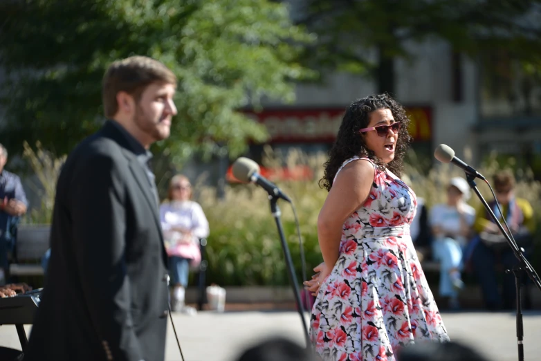 the man and woman are speaking into microphones