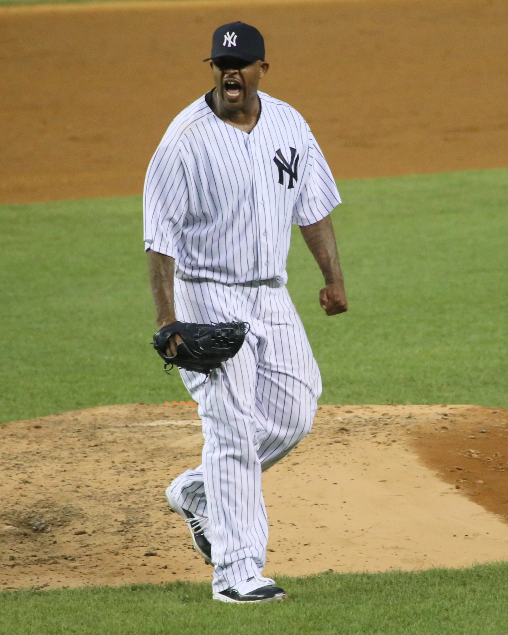 baseball player in the outfield laughing while looking at the ball