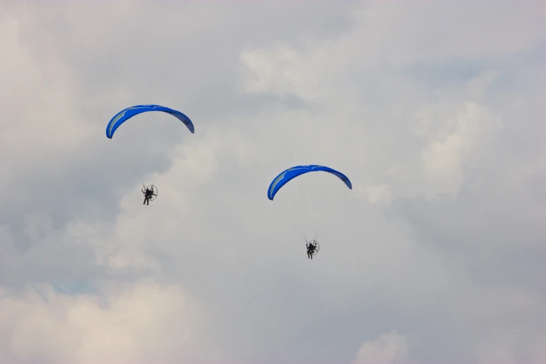 some para - sailers are flying very high in the sky